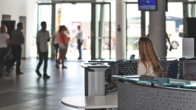 Eine Frau sitzt an der Rezeption