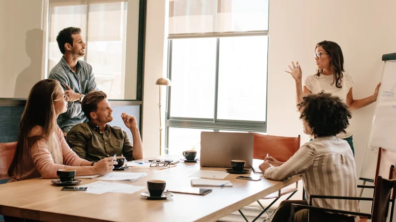Kreatives Geschäftsteam diskutiert im Konferenzraum über neue Projekte. Geschäftsmann und Frau treffen sich im Sitzungssaal, um neue Geschäftsstrategien zu erkunden.