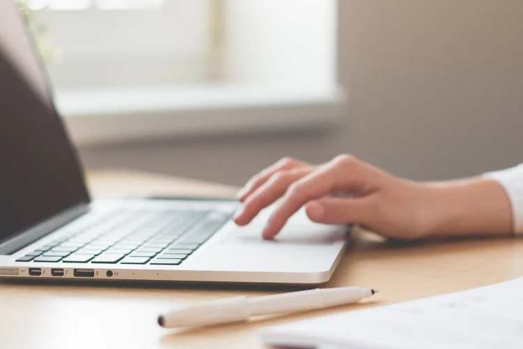 Hand tippt auf einem Laptop