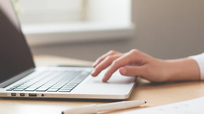 Hand tippt auf einem Laptop