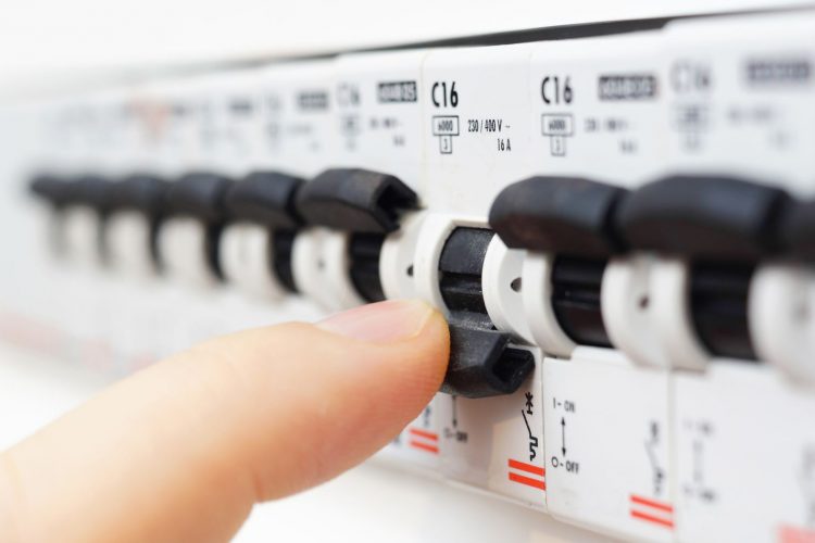 Mann schaltet den Sicherungskasten aus