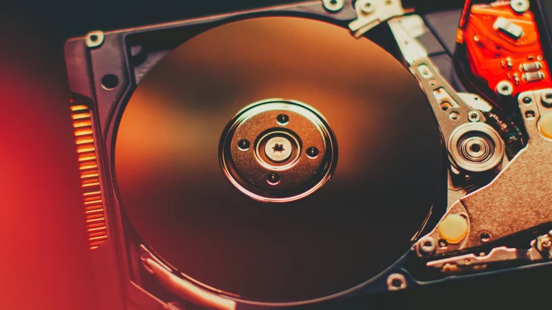 Computertechnik. Öffnen Sie die zerlegte Festplatte. PC, Laptop-Komponente. Roter Lens Flare-Effekt.