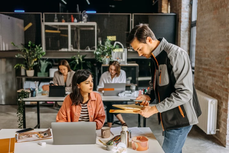Zusteller liefert Post an Frau im Büro