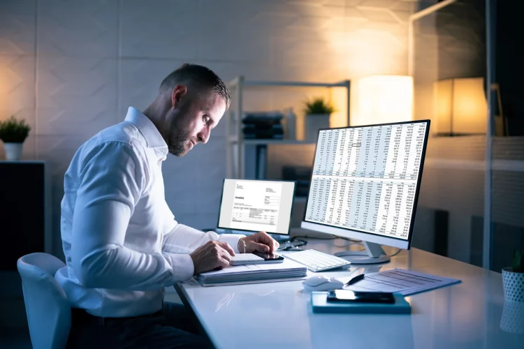 Buchhalter-Mann im Büro nachts mit Steuerdokumenten