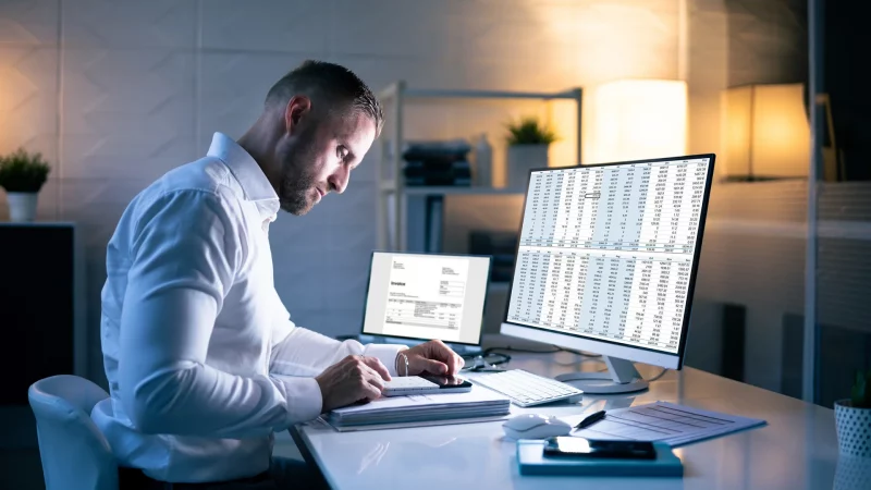 Buchhalter-Mann im Büro nachts mit Steuerdokumenten